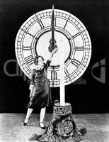 Woman with candle and clock on New Years Eve