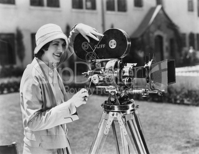 Woman using movie camera outdoors