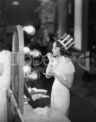 Woman in costume applying makeup