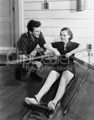 Man with woman using rowing machine