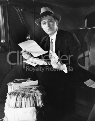 Man in car with bundles of mail