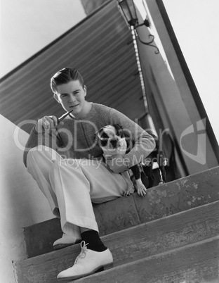 Portrait of young man smoking pipe with dog