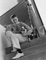 Portrait of young man smoking pipe with dog