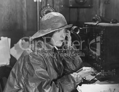 Woman in raincoat sending message in Morse code