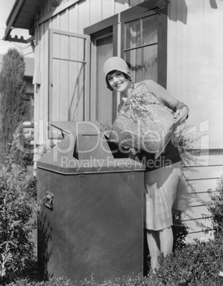 Portrait of woman taking out trash
