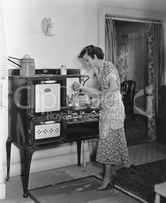 Woman cooking on antique stove