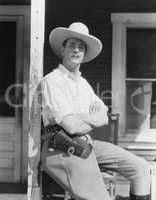 Man on porch wearing cowboy hat
