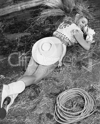Smiling cowgirl lying on ground
