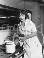 Portrait of woman stirring pot on stove