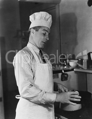 Man in chef hat and apron cooking
