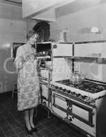 Woman with large stove holding pan