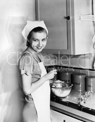 Portrait of woman cooking with flour on face