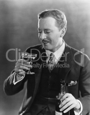 Smiling man with beverage and bottle