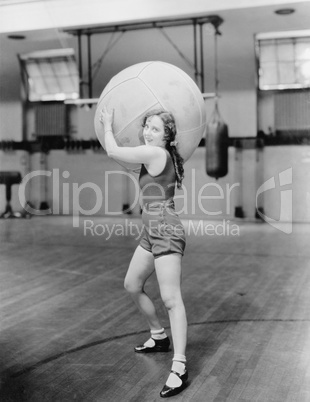 Woman in gymnasium with huge ball