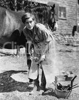 Woman shoeing horse
