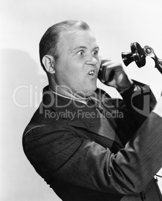 Man with funny expression using telephone