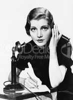 Portrait of woman on telephone taking notes