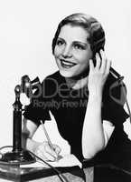 Smiling woman using telephone