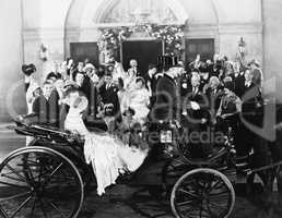 Newlyweds leaving wedding in carriage