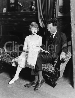 Man and woman on couch with paperwork