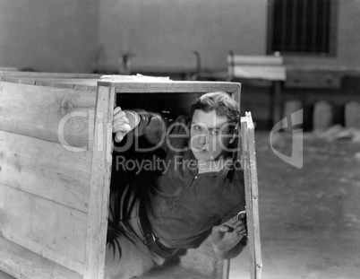 Man hiding in wooden crate