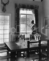 Man standing at window in dining room