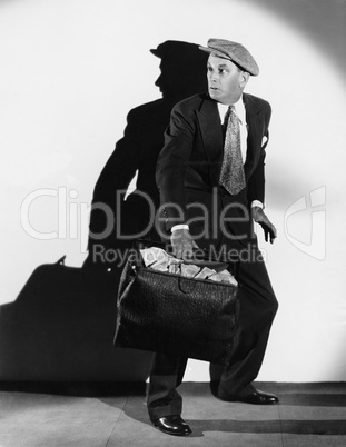 Anxious man with bag of cash