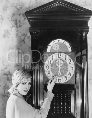Woman with grandfather clock at midnight