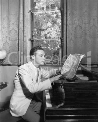 Man at piano with sheet music