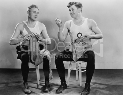 Two men knitting and sewing