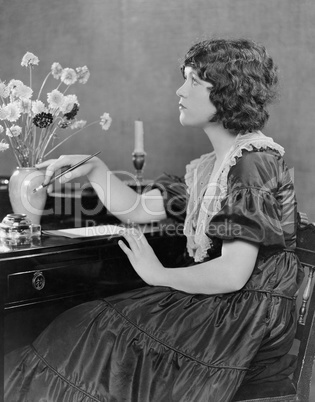 Portrait of woman writing at desk