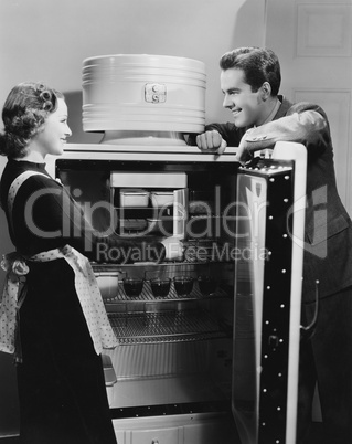 Couple with open refrigerator