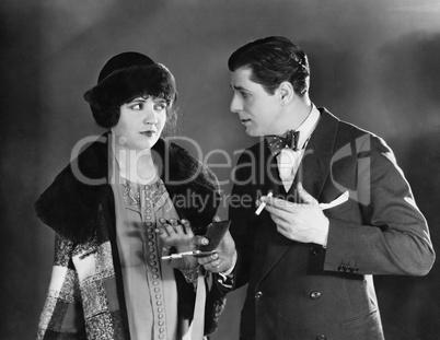 Man with cigarettes talking to woman