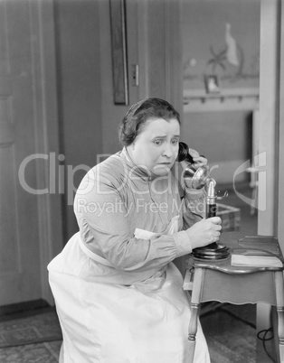 Worried woman using telephone