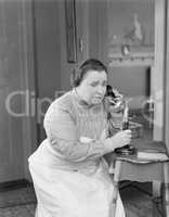 Worried woman using telephone