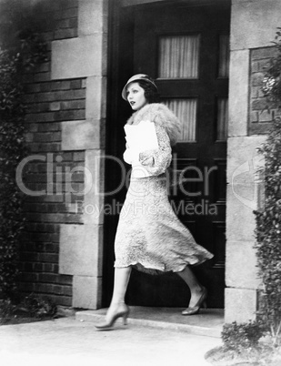 Young woman walking out door