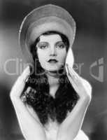 Portrait of woman bending edges of hat