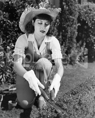 Woman trimming hedge