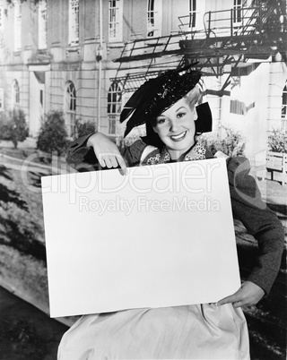 Smiling woman holding blank sign