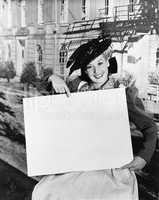 Smiling woman holding blank sign