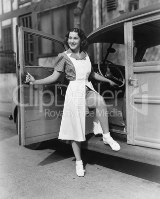 Woman posing at door of car