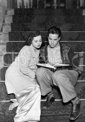 Couple reading together on stairs