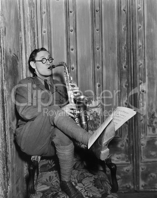 Saxophone player reading music on foot