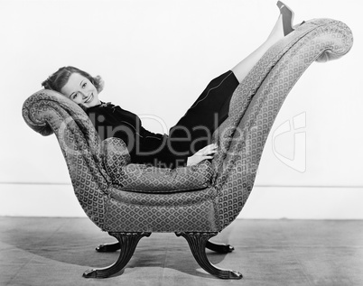 Portrait of woman on curved piece of furniture