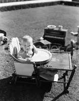 Baby in highchair outside