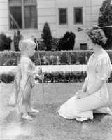 Baby cupid shooting apple on womans head