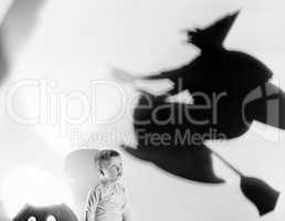 Child with silhouette of witch and jack o lantern