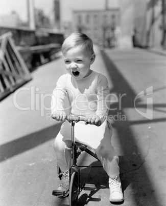 Portrait of kid riding tricycle