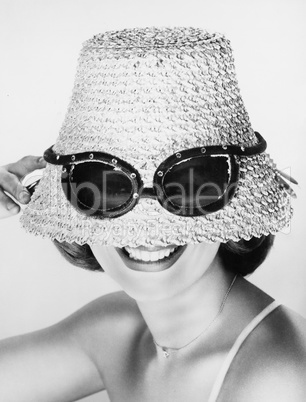 Woman wearing hat with fake sunglasses