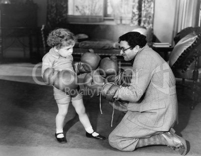 Father and young son playing with boxing gloves
